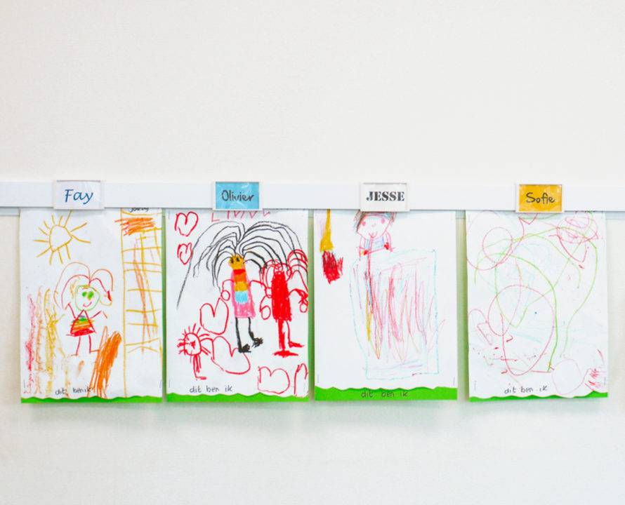 EN colored drawings in info rail in classroom with name clips