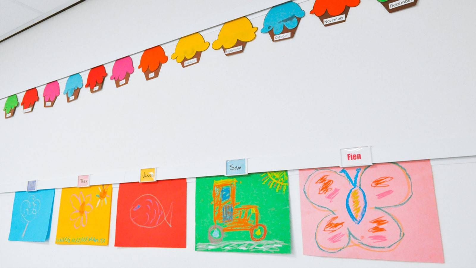 NL Info Rail ophangsysteem met kindertekeningen aan de muur in de klas