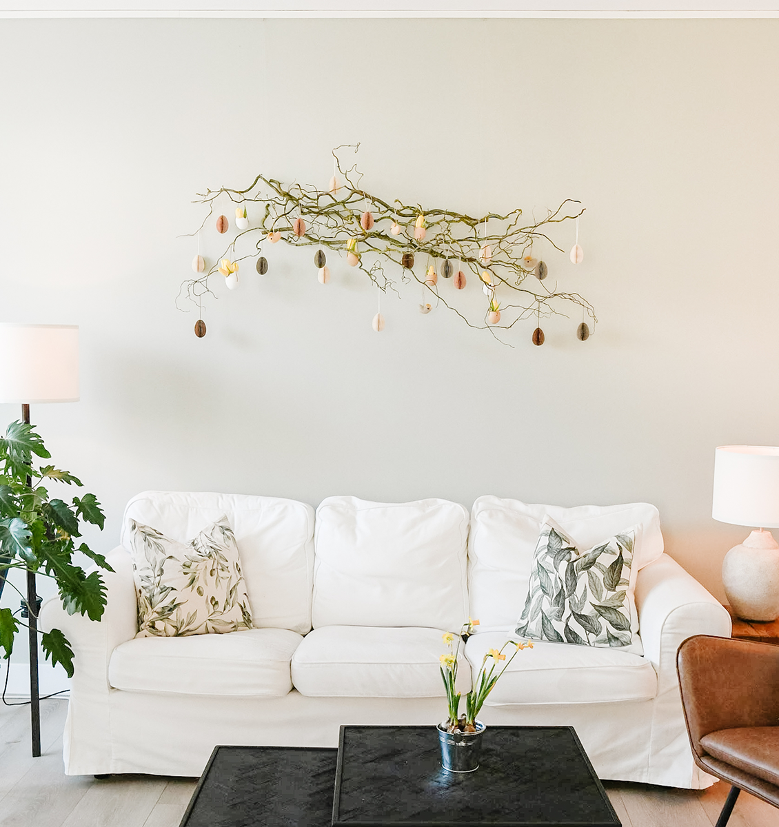 FR Branche de Pâques avec décoration sur le mur au-dessus du canapé dans le salon