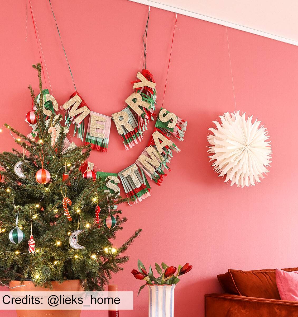 NL kerstslinger en ster aan roze muur in woonkamer