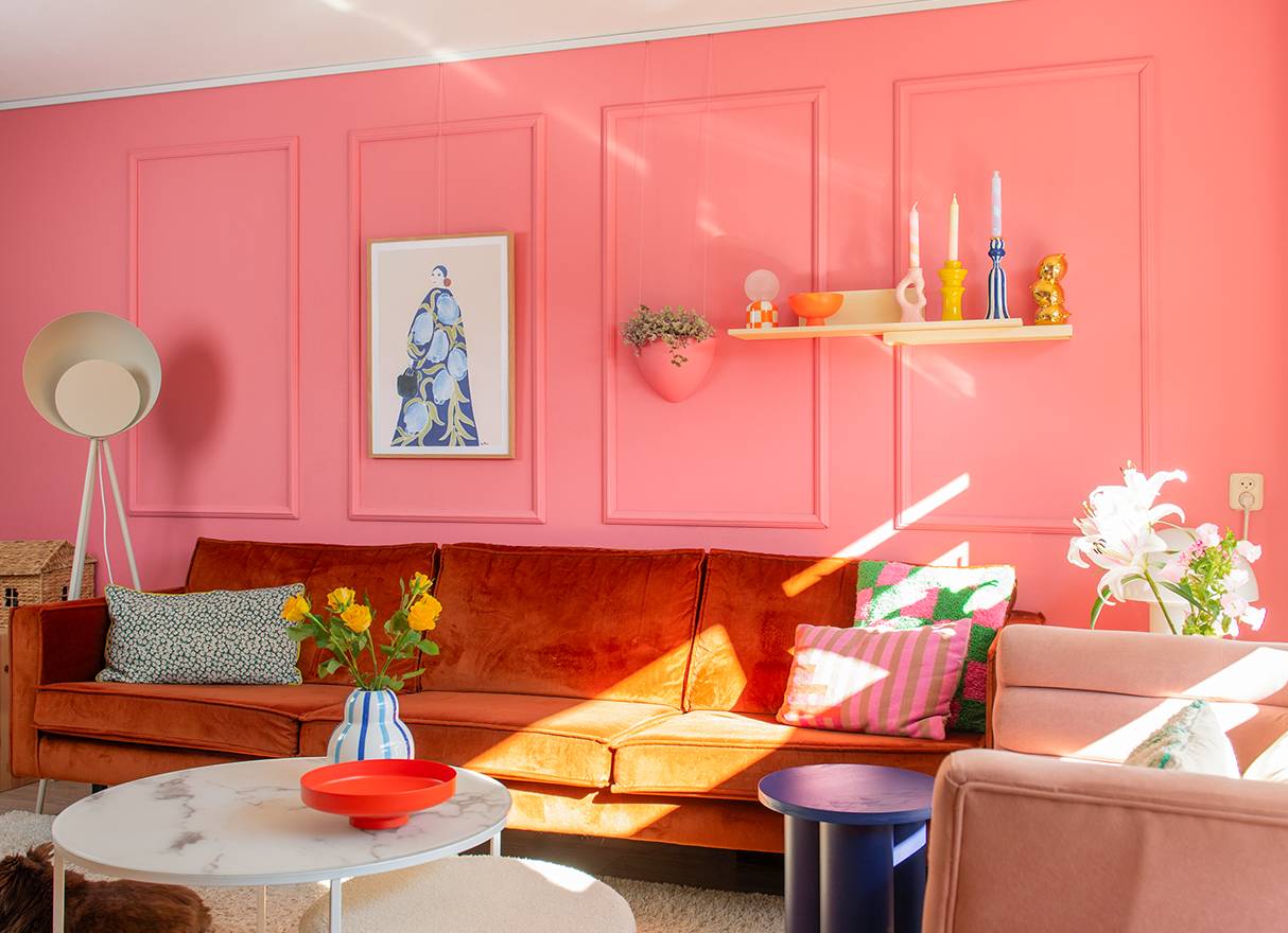 NL roze wand met bloempot en lijst aan de muur in de woonkamer