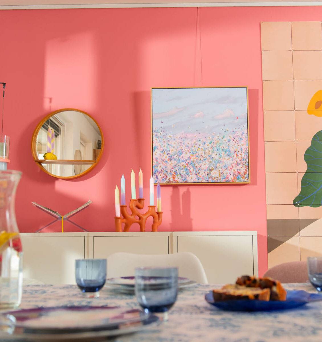 NL eetkamer met roze muur en kleurrijke details