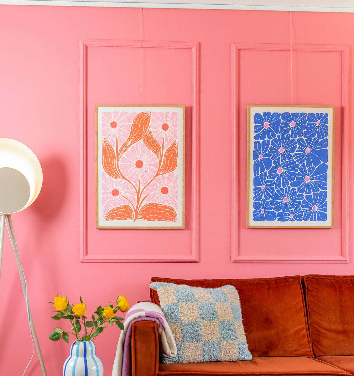 NL roze wand in de woonkamer met 2 kleurrijke bloemposters aan de wand