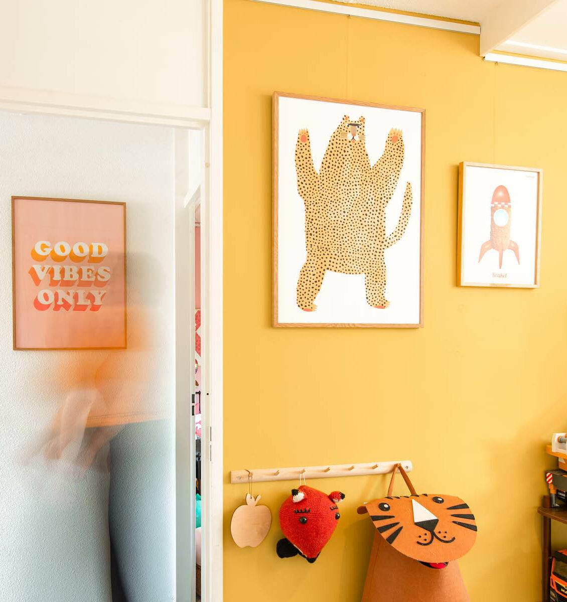 NL kinderkamer met gele muur en organische vormen kinderposters aan de wand