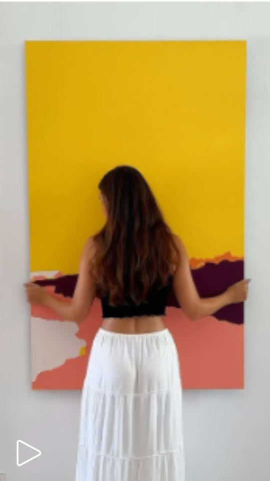 EN girl hanging a painting on the wall