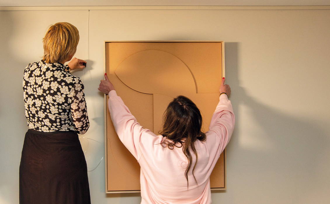 NL groot geel schilderij ophangen met vrouw met roze trui